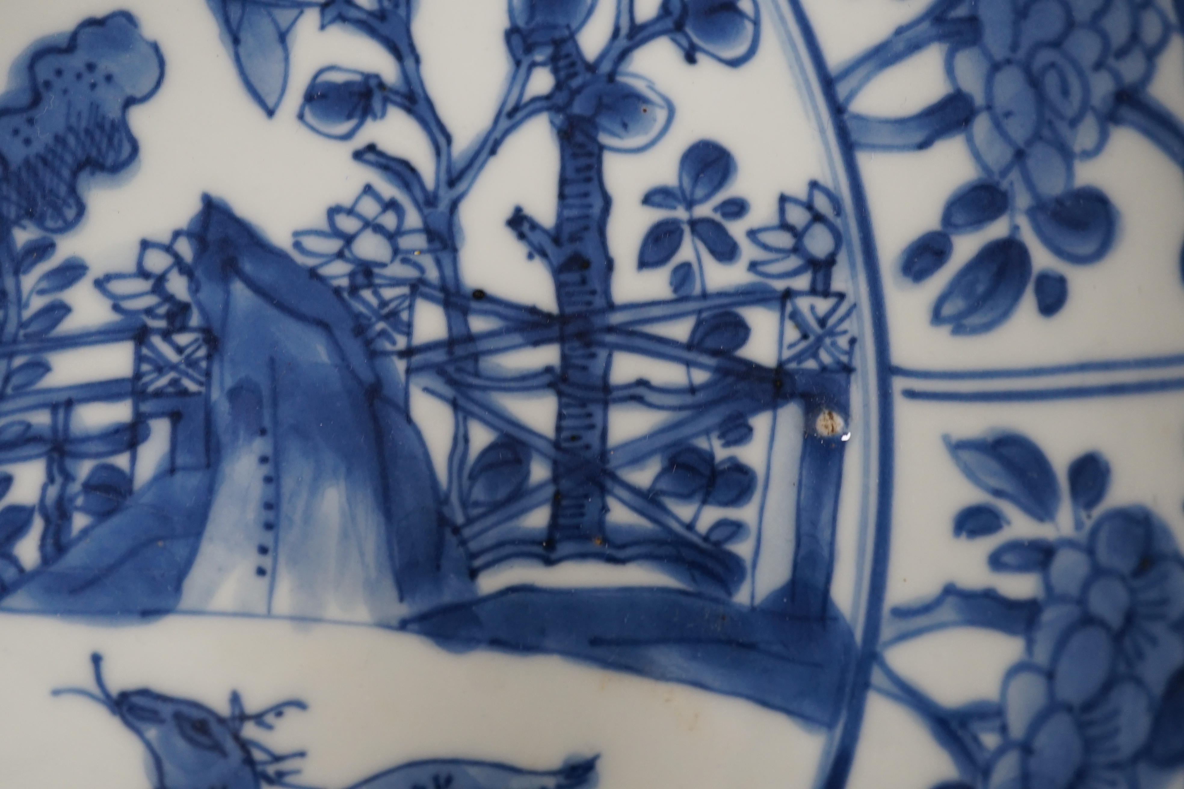 A pair of Chinese blue and white ‘garden’ dishes, Kangxi period, fritting and glaze chips